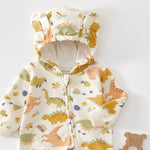 Close-up of the cream dinosaur romper's hood with two bear ears and the top of the zip