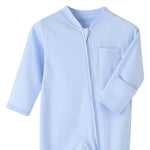 Close-up of the light blue romper: fabric guard at the top of the zip, chest pocket and fold-over hand cuff
