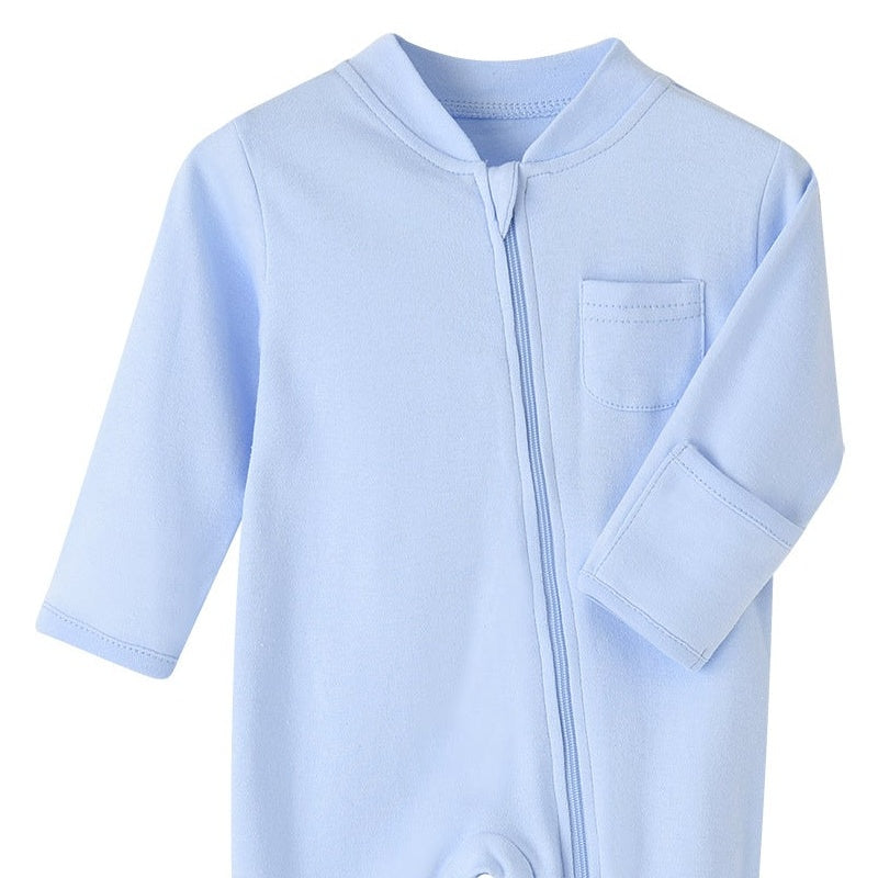 Close-up of the light blue romper: fabric guard at the top of the zip, chest pocket and fold-over hand cuff