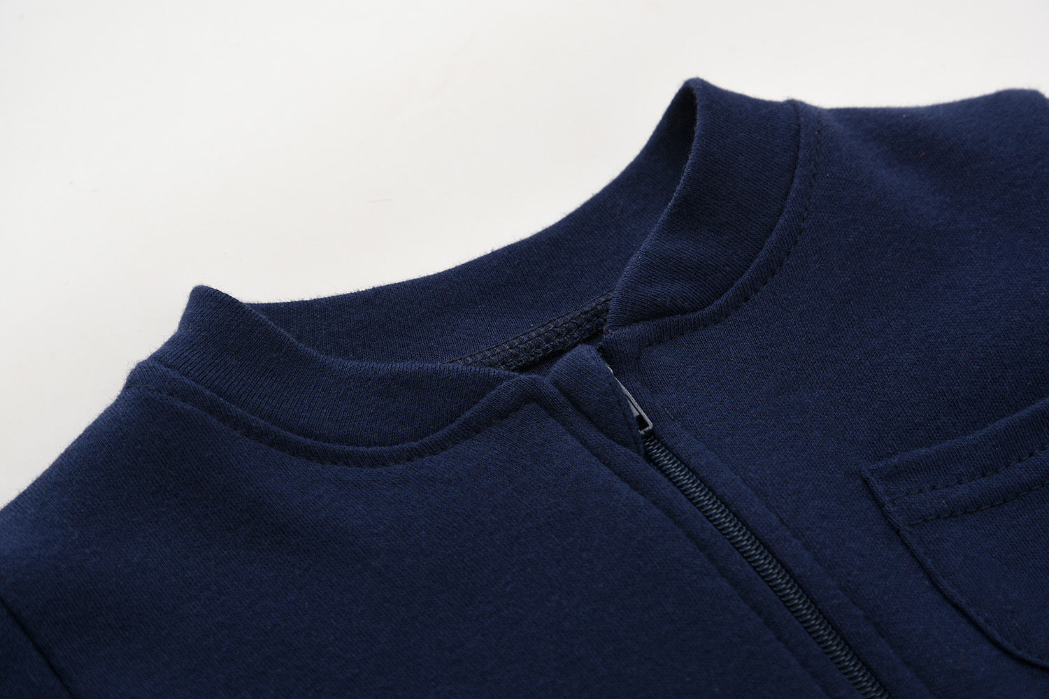 Close-up of the navy romper's stand collar and the top of the zip