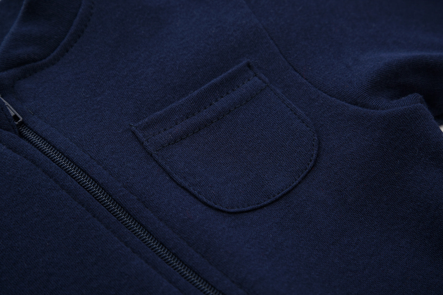 Close-up of the chest patch pocket and the zip on the navy romper