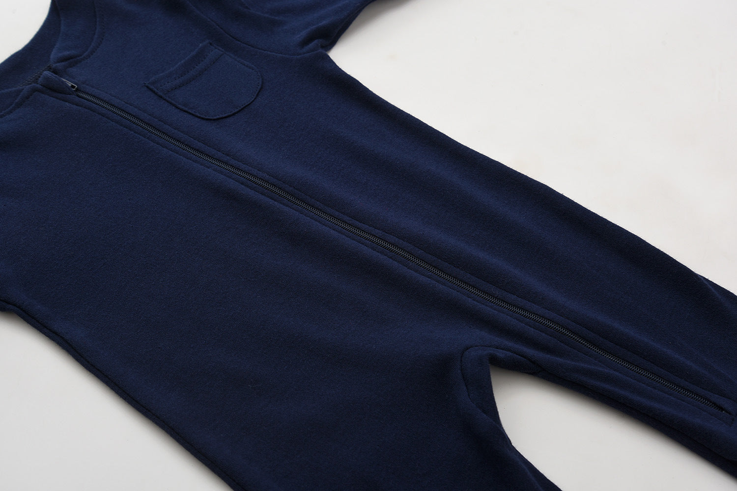 The zip running from the neck down the front of the navy romper