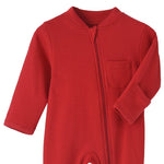 Close-up of the red romper: fabric guard at the top of the zip, chest pocket and fold-over hand cuff