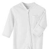 Close-up of the white romper: fabric guard at the top of the zip, chest pocket and fold-over hand cuff