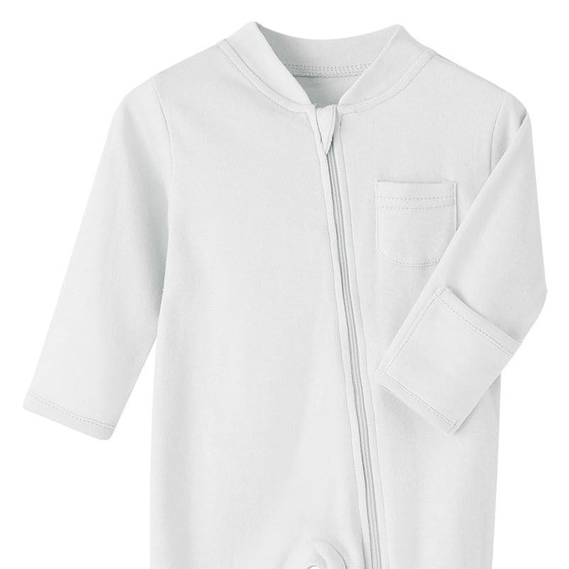Close-up of the white romper: fabric guard at the top of the zip, chest pocket and fold-over hand cuff