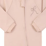 Close-up of the dusty pink embroidered bow print, the cotton jersey and the zip
