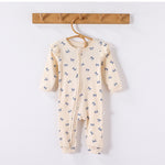 Cream Bows frill-shoulder romper on a wooden hanger, front view showing the zip down one leg and the ankle cuffs