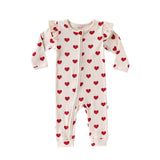 Cream Hearts baby romper with frilled shoulders and a two-way zip from the neck down one leg, laid flat, front view