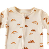 Close-up of the cream croissant print, the rib texture and the fabric cover at the top of the zip