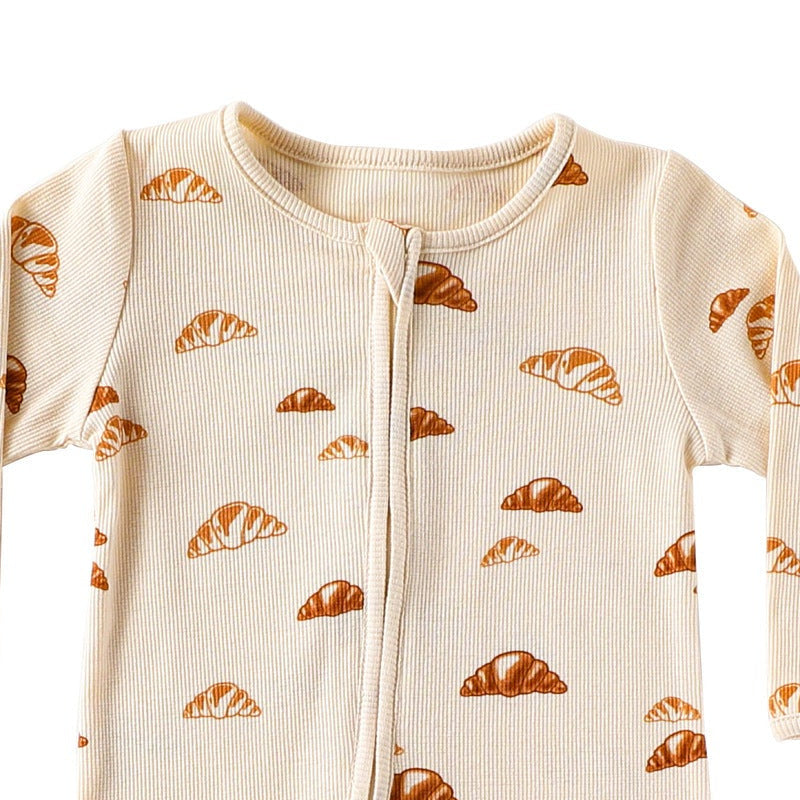 Close-up of the cream croissant print, the rib texture and the fabric cover at the top of the zip