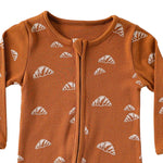 Close-up of the rust croissant print, the rib texture and the fabric cover at the top of the zip