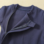 Close-up of the zip opened at the neck, under its fabric strip, with the small fabric tab at the top