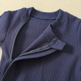 Close-up of the zip opened at the neck, under its fabric strip, with the small fabric tab at the top