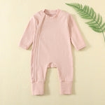 Peach Pink ribbed baby romper with a zip from the neck to one ankle and fold-over cuffs, laid flat