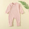 Peach Pink ribbed baby romper with a zip from the neck to one ankle and fold-over cuffs, laid flat
