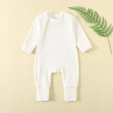 White ribbed baby romper with a zip from the neck to one ankle and fold-over cuffs, laid flat