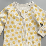 Close-up of the grey sunshine print, the rib knit and the top of the zip