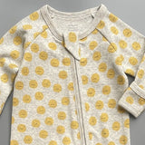 Close-up of the grey sunshine print, the rib knit and the top of the zip
