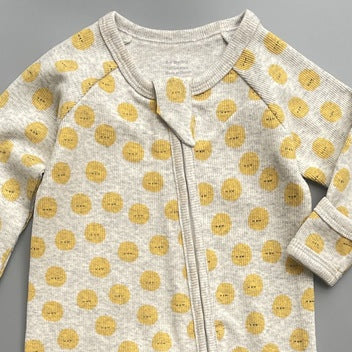 Close-up of the grey sunshine print, the rib knit and the top of the zip