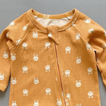 Close-up of the orange bunny print, the rib knit and the top of the zip