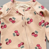 Close-up of the peach cherry print, the rib knit and the top of the zip