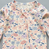 Close-up of the pink floral print, the rib knit and the top of the zip