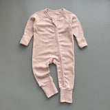 Pink red spot ribbed zip baby sleepsuit with fold-over hand and foot cuffs, laid flat