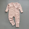 Pink red spot ribbed zip baby sleepsuit with fold-over hand and foot cuffs, laid flat
