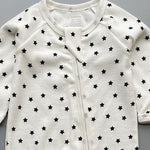 Close-up of the white black star print, the rib knit and the top of the zip