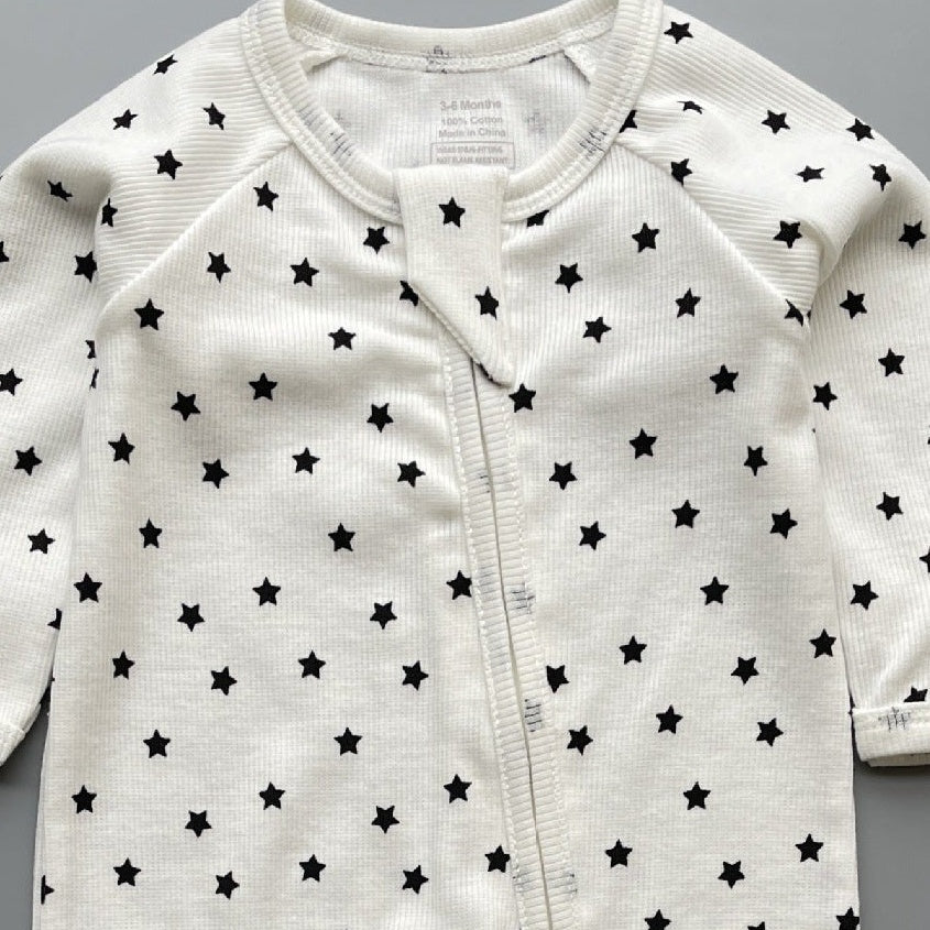 Close-up of the white black star print, the rib knit and the top of the zip