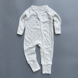 White navy spot ribbed zip baby sleepsuit with fold-over hand and foot cuffs, laid flat