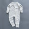 White navy spot ribbed zip baby sleepsuit with fold-over hand and foot cuffs, laid flat