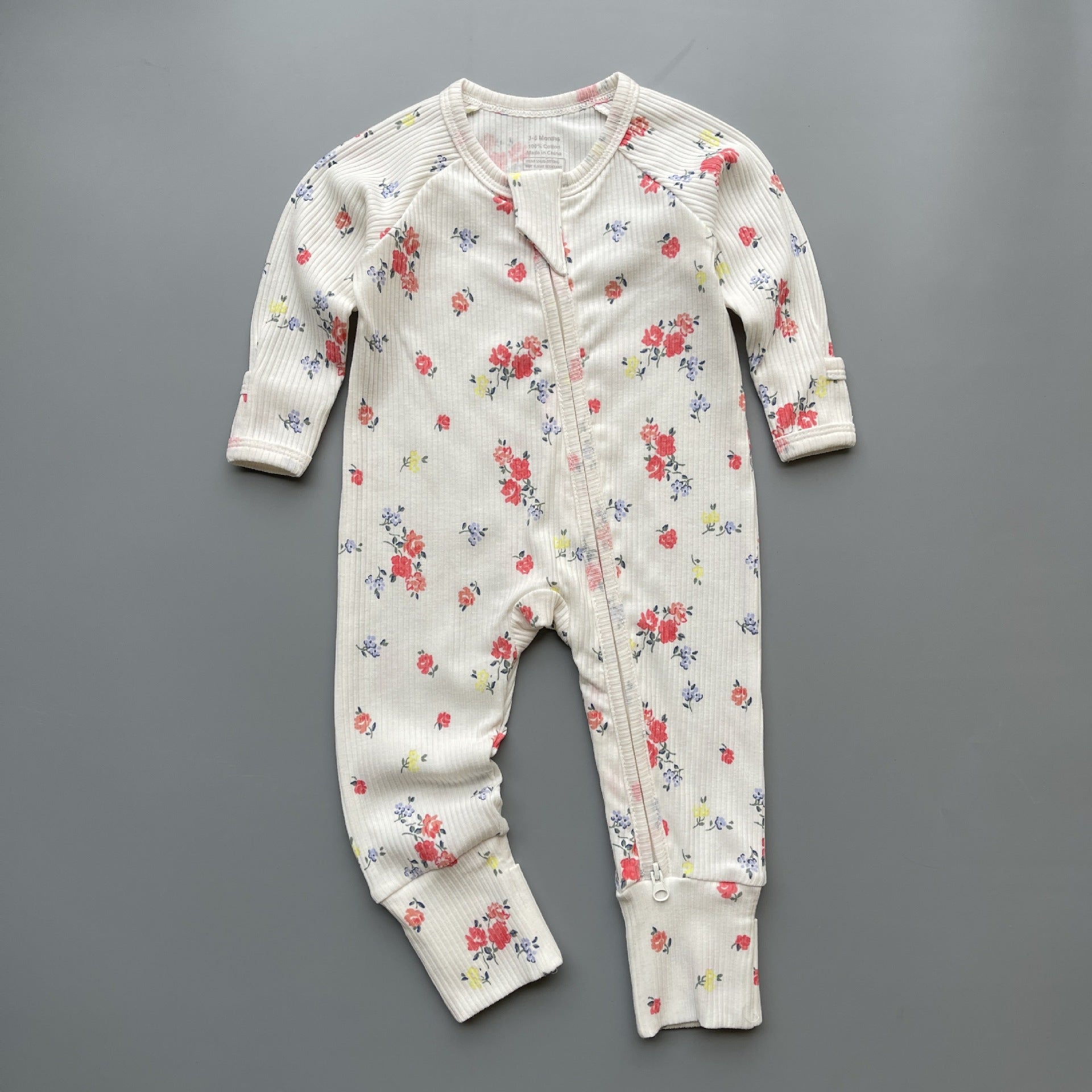 White rose ribbed zip baby sleepsuit with fold-over hand and foot cuffs, laid flat
