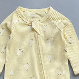 Close-up of the yellow goose print, the rib knit and the top of the zip