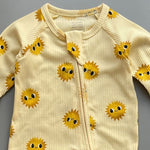 Close-up of the yellow sunshine print, the rib knit and the top of the zip