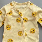 Close-up of the yellow sunshine print, the rib knit and the top of the zip