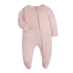 Plain dusty pink baby romper with a zip from one ankle to the neck, covered feet and fold-over cuffs, laid flat