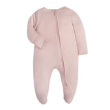 Plain dusty pink baby romper with a zip from one ankle to the neck, covered feet and fold-over cuffs, laid flat