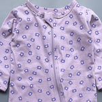 Close-up of the purple bear-head print on lilac jersey and the top of the zip