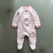 Pink zigzag zip baby sleepsuit with covered feet and a snap tab at the neck, laid flat