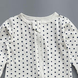 Close-up of the white navy polka dot print, the cotton jersey and the top of the zip