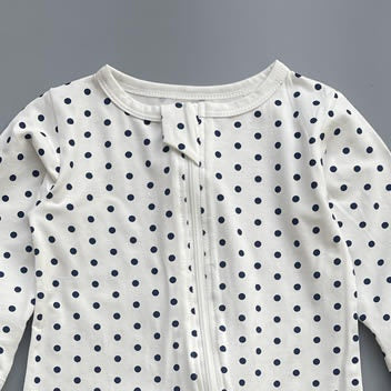 Close-up of the white navy polka dot print, the cotton jersey and the top of the zip