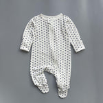 White navy polka dot zip baby sleepsuit with covered feet and fold-over hand cuffs, laid flat