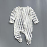 White navy polka dot zip baby sleepsuit with covered feet and fold-over hand cuffs, laid flat