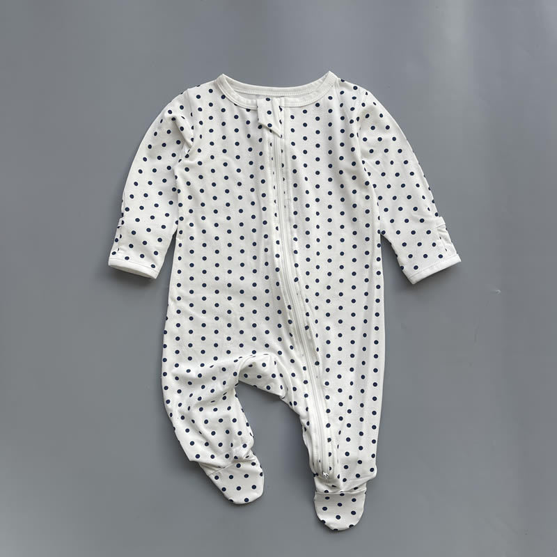 White navy polka dot zip baby sleepsuit with covered feet and fold-over hand cuffs, laid flat